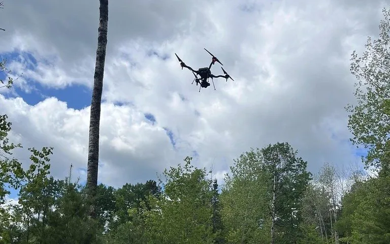 Dron industrial en vuelo sobre un bosque durante una operación
