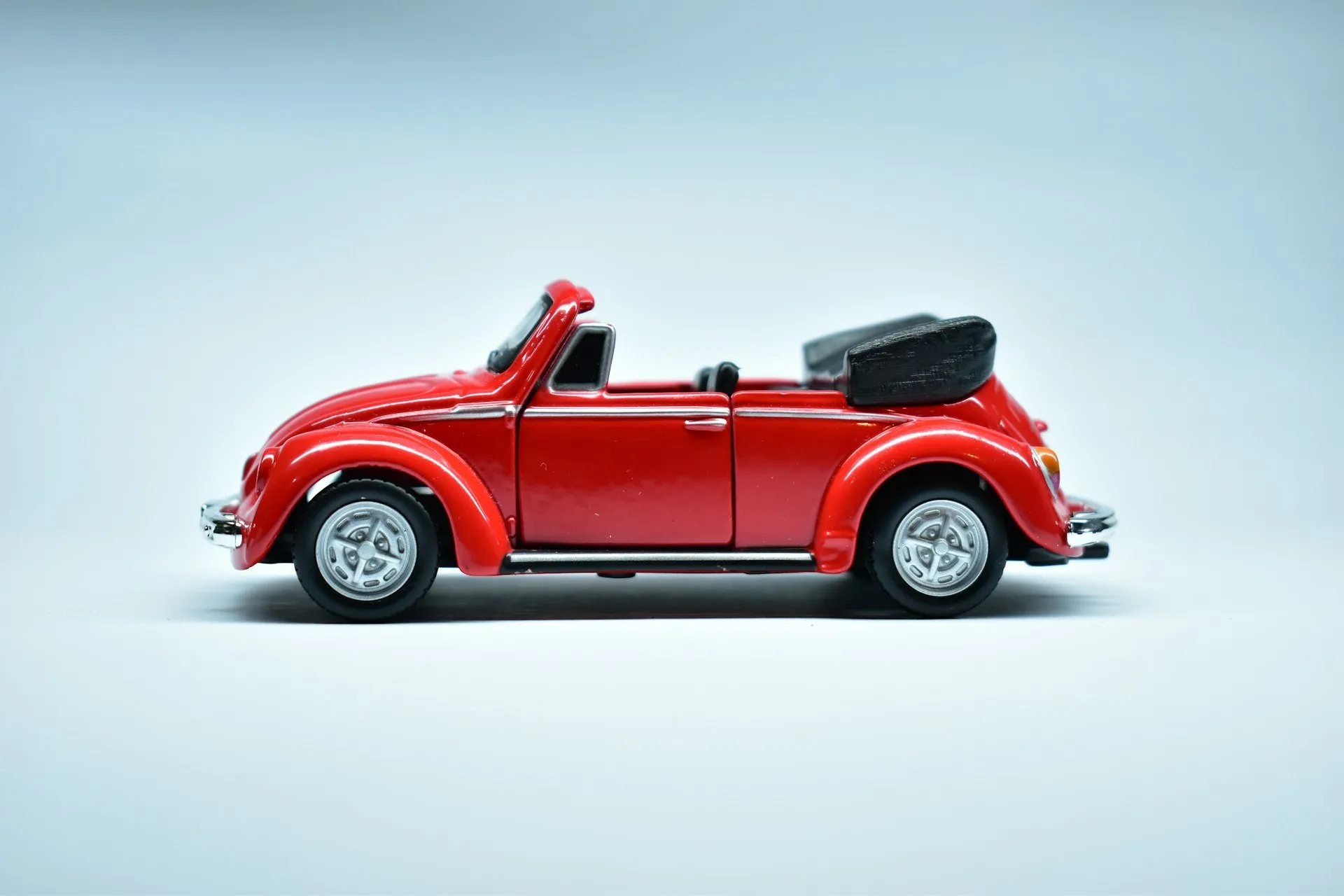 Carro a escala en miniatura color rojo sobre fondo claro