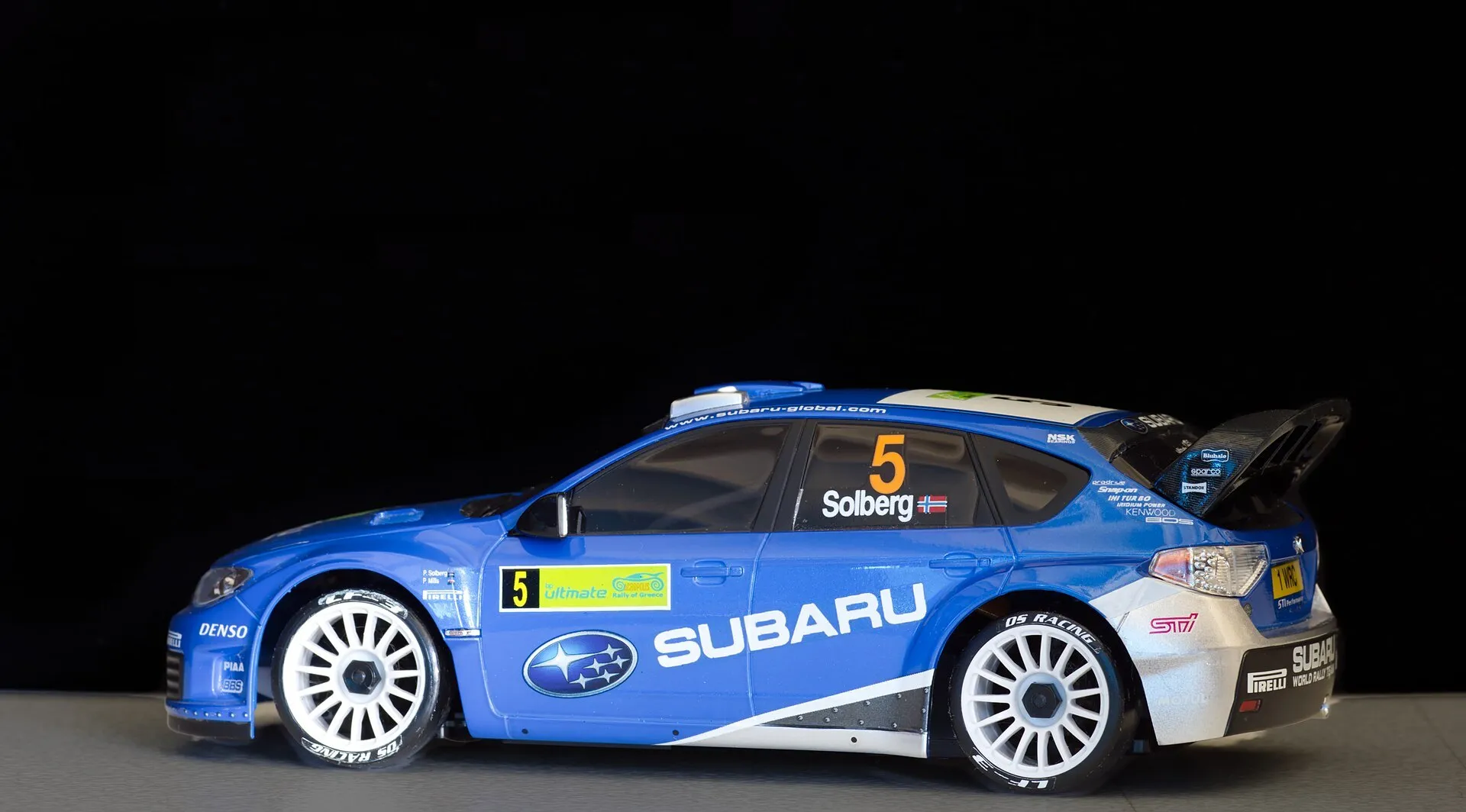 Carro de radio control de rally azul sobre fondo negro