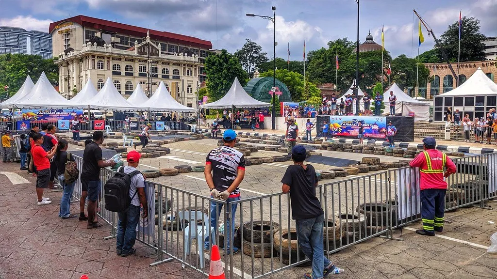 Pista de carros RC al aire libre con pilotos y público alrededor