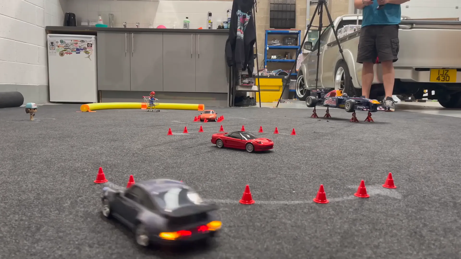 RC Porsche 911 realizando drift en circuito con conos y obstáculos