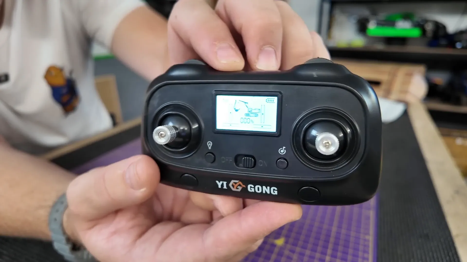 Control remoto del excavador RC mostrando pantalla y botones de función
